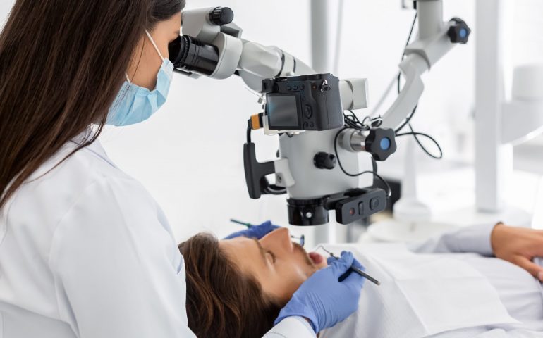 Professional dentist doctor making treatment in modern cabinet